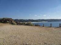 a gravel field with a beach on one side and mountains in the back ground to the other