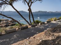 a bike is parked along the path by the ocean with a view of mountains in the distance