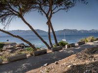 a bike is parked along the path by the ocean with a view of mountains in the distance