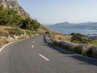 an empty winding road beside a scenic bay and mountainous mountains in croatia, europe, asia