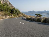 an empty winding road beside a scenic bay and mountainous mountains in croatia, europe, asia