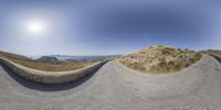 a 360 - camera shot of some hill with a sky background, including an air ball, and sun above the ground