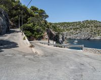 a paved road beside some large boats and a bridge with a bridge to the water