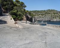 a paved road beside some large boats and a bridge with a bridge to the water