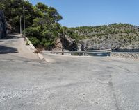 a paved road beside some large boats and a bridge with a bridge to the water