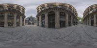 two fish - eye images are shown in the same photo as a person walks in front of some buildings