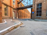 an empty alley next to the road under a metal bridge in an old brick building