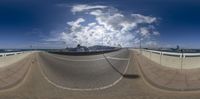 a very wide street is shown with a cloudy sky in the background and in the foreground, there are three lines going through it