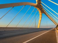 an empty bridge with many white lines on it under blue skies at dusk, near the highway in california