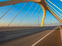 an empty bridge with many white lines on it under blue skies at dusk, near the highway in california