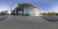 a fish eye lens photograph of an urban building with a curved walkway at the base of it