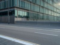 the road is empty on this busy street with the tall building in the background for pedestrians