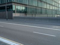 the road is empty on this busy street with the tall building in the background for pedestrians