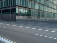 the road is empty on this busy street with the tall building in the background for pedestrians