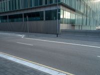 the road is empty on this busy street with the tall building in the background for pedestrians