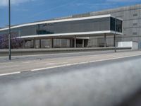 an empty road outside an office building, overlooking the street from the front door with a view through the windows