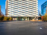 a building is pictured in this image with no clouds in the sky and two people riding their skateboards