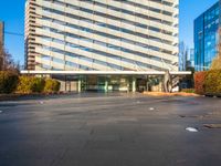 a building is pictured in this image with no clouds in the sky and two people riding their skateboards