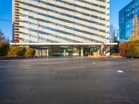 a building is pictured in this image with no clouds in the sky and two people riding their skateboards