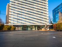 a building is pictured in this image with no clouds in the sky and two people riding their skateboards