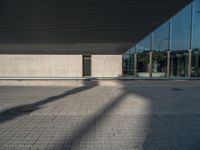 a white building next to a pool in a courtyard area with a walkway leading into it