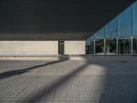 a white building next to a pool in a courtyard area with a walkway leading into it