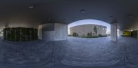 a view looking out at a building and a building inside from an open doorway and a circular perspective on the walkway