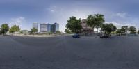 two cars parked at an empty intersection with tall buildings in the back ground on either side