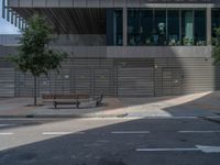 a park bench is by an empty bench on the side of a street and in front of a building