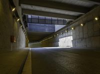 a concrete roadway has a lot of light coming from under it as if by the tunnel