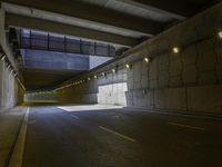 a concrete roadway has a lot of light coming from under it as if by the tunnel