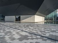 a white building next to a pool in a courtyard area with a walkway leading into it