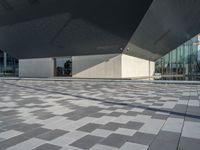 a white building next to a pool in a courtyard area with a walkway leading into it