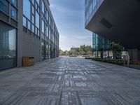 a long path in a large courtyard between two buildings and a street that runs parallel