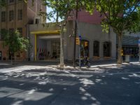 the street is empty of cars as a motorcycle passes by the building with yellow door