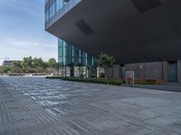 the empty walkway on the sidewalk between buildings is clean and bright, including a sign that reads welcome