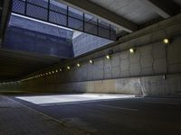 a road in an underpass with lights on it is empty and the road is mostly empty