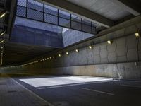 a road in an underpass with lights on it is empty and the road is mostly empty