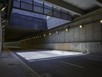 a road in an underpass with lights on it is empty and the road is mostly empty