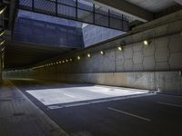 a road in an underpass with lights on it is empty and the road is mostly empty