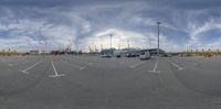 the large commercial car park has cars parked in the lot under the clouds and blue sky