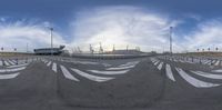 this is a panoramic view from a street side parking area, the sky and stadium are in the background