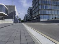 a paved road with no cars on it, and buildings in the background on a sunny day