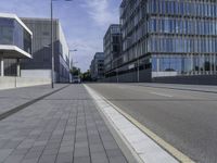 a paved road with no cars on it, and buildings in the background on a sunny day