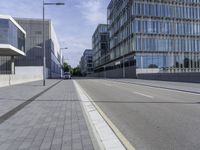 a paved road with no cars on it, and buildings in the background on a sunny day