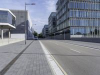 a paved road with no cars on it, and buildings in the background on a sunny day