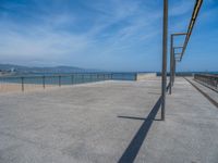 a walkway with rails and railings next to the water and beach near by,