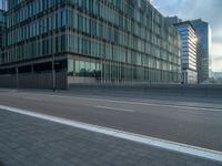 the road is empty on this busy street with the tall building in the background for pedestrians