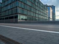 the road is empty on this busy street with the tall building in the background for pedestrians