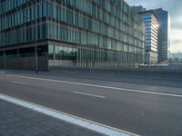 the road is empty on this busy street with the tall building in the background for pedestrians